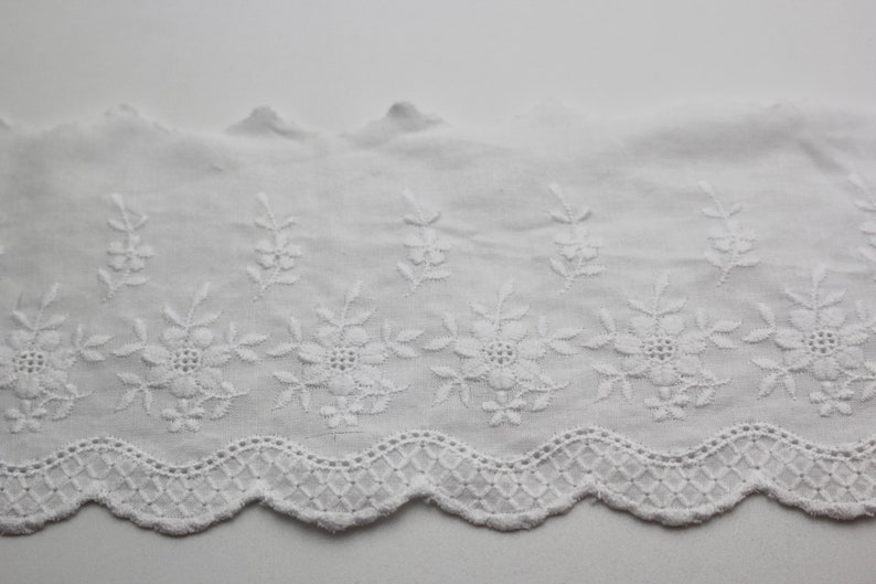 Peut inclure: Garniture en dentelle de coton blanche avec un bord festonn&eacute; et un motif floral brod&eacute;.