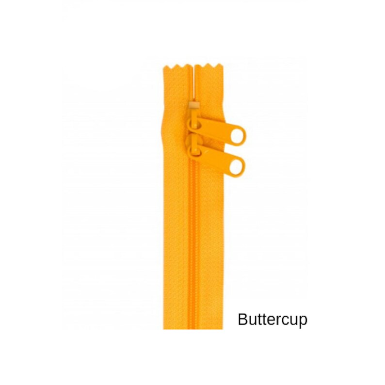 May include: A bright yellow zipper with a double slider and a metal pull. The zipper is labeled "Buttercup".