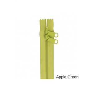 May include: A green zipper with two pull tabs. The zipper is closed and the pull tabs are at the top. The zipper is labeled "Apple Green".