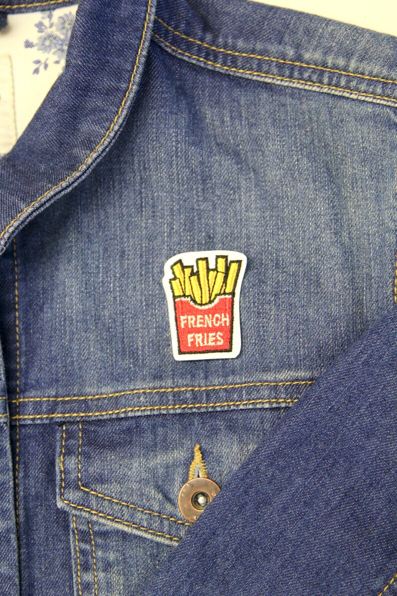 May include: A blue denim jacket with a red and yellow embroidered patch that says "French Fries".