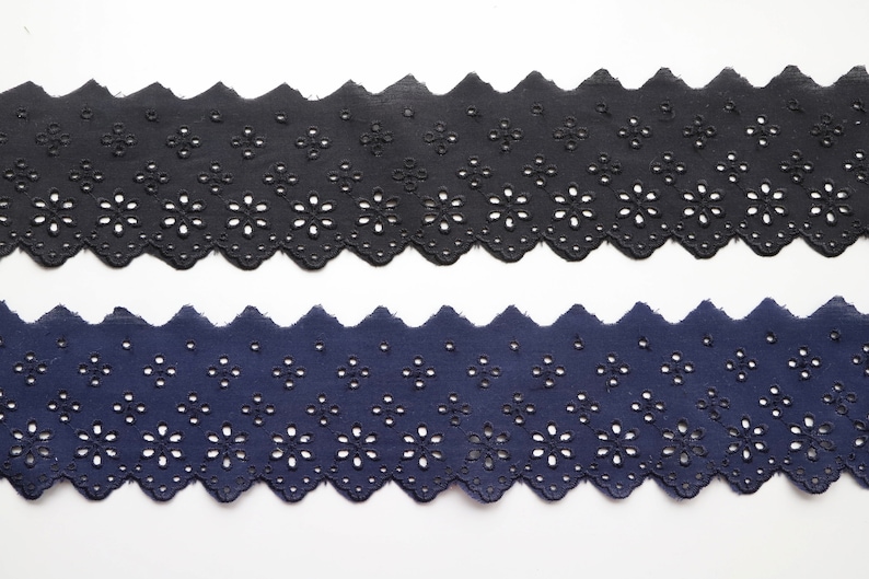 May include: Two pieces of black and navy blue cotton lace trim with a scalloped edge and a floral pattern.