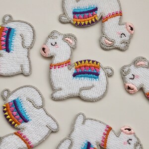 Puede incluir: Siete parches de llama bordados blancos con dise&ntilde;os geom&eacute;tricos coloridos. Las llamas est&aacute;n en varias poses, incluyendo de pie, sentadas y acostadas.