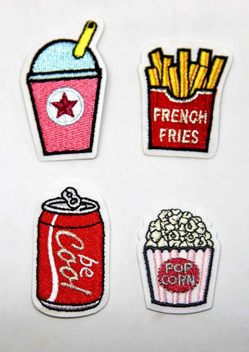 May include: Four embroidered iron-on patches featuring a red can of soda with the word "Coca-Cola" on it, a pink slushie with a straw and a red star, a red box of french fries with the words "French Fries" on it, and a white box of popcorn with the words "Pop Corn" on it.
