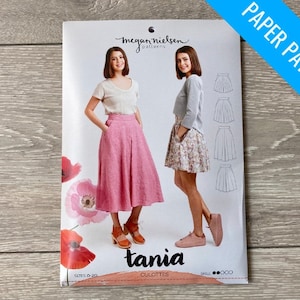 May include: A paper sewing pattern for a skirt called "Tania Culottes" by Megan Nielsen Patterns. The pattern includes two models wearing the skirt in different fabrics and styles. The pattern is for sizes 0-20.