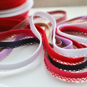 May include: Assortment of elastic trim with lace edging in various colors, including white, red, black, beige, and purple.