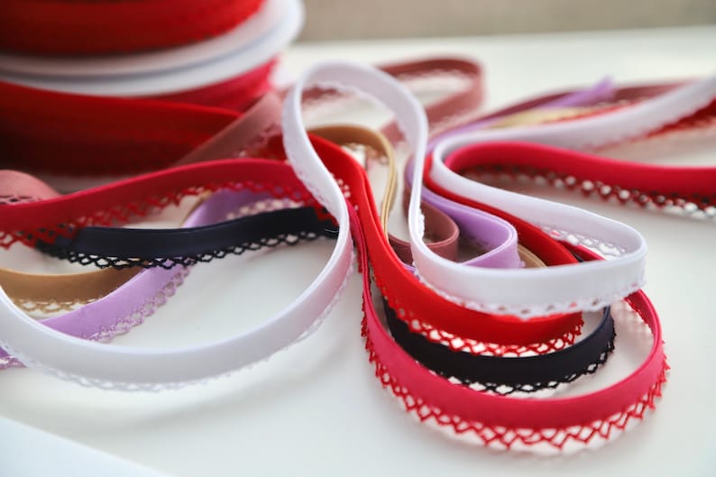 May include: Assortment of elastic trim with lace edging in various colors, including white, red, black, beige, and purple.