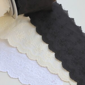 Peut inclure: Trois rouleaux de dentelle en coton blanche, cr&egrave;me et noire avec un bord festonn&eacute; et une broderie florale.