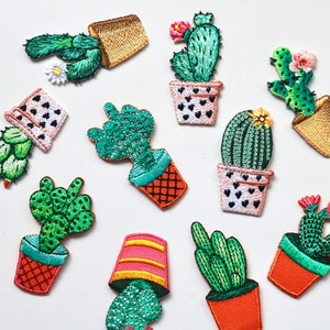 May include: A set of ten embroidered cactus patches in various colours and styles. The patches feature different cactus shapes and sizes, with some having flowers or other embellishments. The patches are perfect for adding a touch of whimsy to clothing, bags, or other accessories.