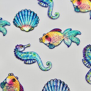 May include: Assortment of colorful, iridescent, sequined sea life patches, including seahorses, fish, and seashells.