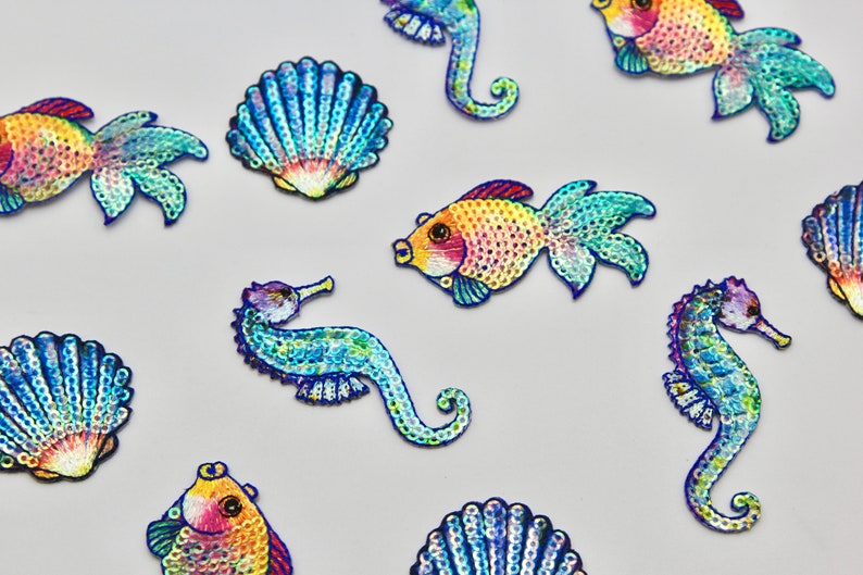 May include: Assortment of colorful, iridescent, sequined sea life patches, including seahorses, fish, and seashells.