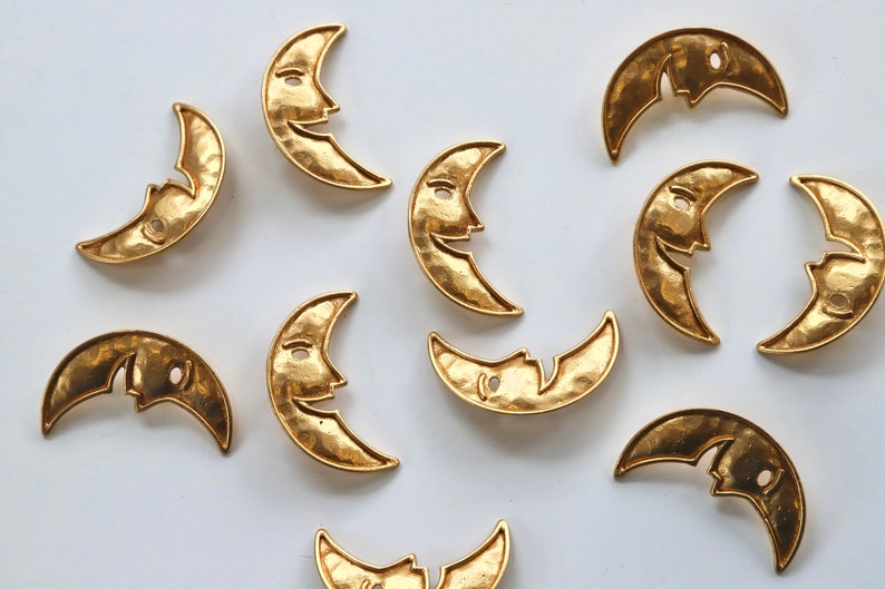 Puede incluir: Una colecci&oacute;n de 10 dijes de metal dorado en forma de media luna con un dise&ntilde;o de cara sonriente. Los dijes tienen una textura martillada y son perfectos para la elaboraci&oacute;n de joyas o manualidades.