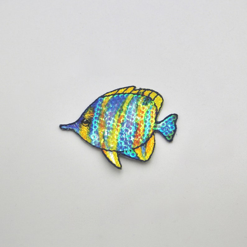 May include: A blue and yellow fish with iridescent scales, embroidered with sequins. The fish is a popular motif for crafts and decorations.