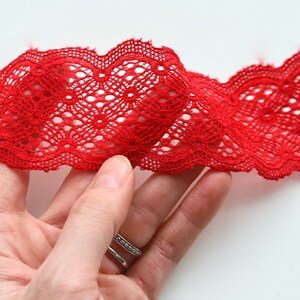 Puede incluir: Borde de encaje rojo con borde festoneado. El encaje tiene un delicado patr&oacute;n floral.