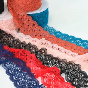 Puede incluir: Surtido de encaje de diferentes colores, incluyendo azul marino, rojo, negro, rosa y naranja. El encaje tiene un borde festoneado y un delicado patr&oacute;n floral.