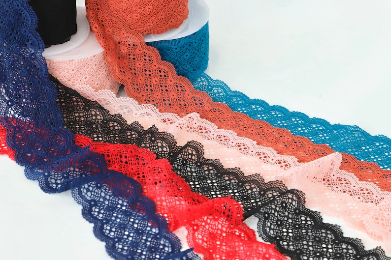Puede incluir: Surtido de encaje de diferentes colores, incluyendo azul marino, rojo, negro, rosa y naranja. El encaje tiene un borde festoneado y un delicado patr&oacute;n floral.