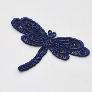 May include: A navy blue lace dragonfly applique. This delicate design is perfect for adding a touch of whimsy to crafts and sewing projects.