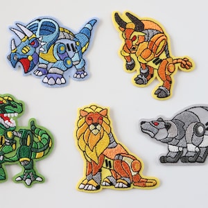 May include: Five embroidered iron-on patches featuring different animal designs. The patches are in a cartoon style and feature a triceratops, a bull, a dinosaur, a lion, and a bear. Each patch has a metallic finish and is in a different colour.