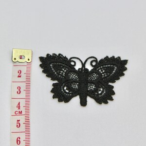 May include: Black lace butterfly applique measuring approximately 4 cm wide.
