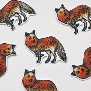 May include: Six embroidered iron-on patches featuring foxes in various poses. The foxes are depicted in shades of orange, brown, and black.