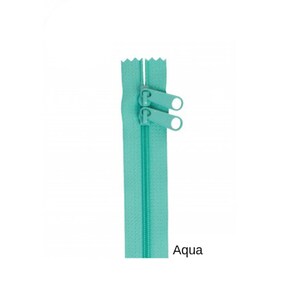 May include: A turquoise zipper with two pull tabs. The zipper is closed and the pull tabs are at the top of the zipper. The zipper is labeled "Aqua".