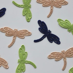 May include: Assortment of delicate dragonfly lace appliques in green, beige, and navy blue. These intricate designs are perfect for adding a touch of whimsy to crafts and sewing projects.