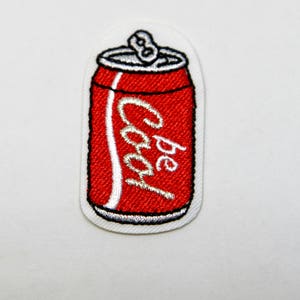 May include: Red and white embroidered iron-on patch of a soda can with the word "Pepsi" on it.