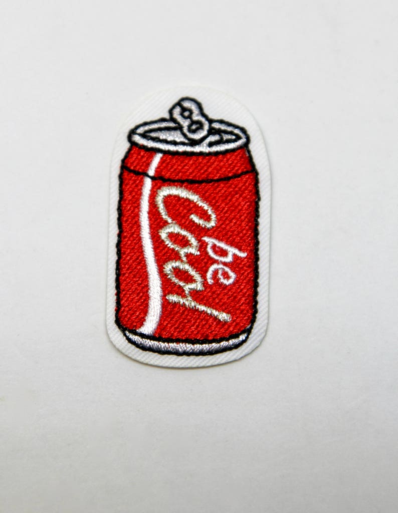 May include: Red and white embroidered iron-on patch of a soda can with the word "Pepsi" on it.