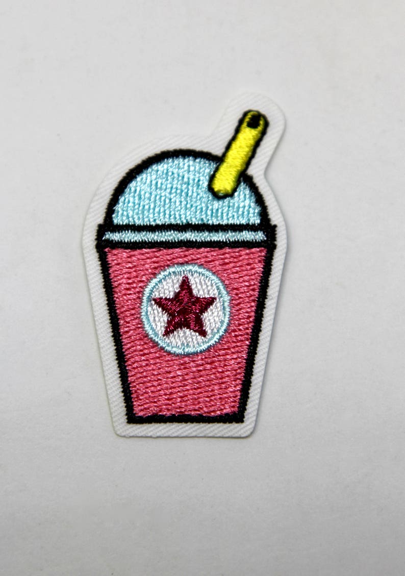 May include: An embroidered iron-on patch of a pink slushie cup with a yellow straw and a red star on the side.