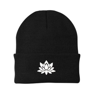 May include: Black beanie with a white lotus flower design.