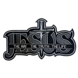 Op de afbeelding: Geborduurde patch met het woord "JESUS" in een gestileerd lettertype, met een kruis en de tekst "THE WAY THE TRUTH THE LIFE". De patch is voornamelijk zwart, grijs en wit.