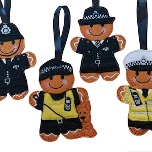 May include: Four gingerbread ornaments decorated as police officers. Each ornament has a different uniform and hat. The ornaments are made of felt and have embroidered details.