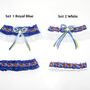 May include: Two sets of garters, one royal blue and one white, each featuring a Superman logo pattern. The sets include a garter with a bow and a smaller garter. The text "Set 1 Royal Blue" and "Set 2 White" are visible.