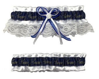 May include: Two-piece wedding garter set. The top garter features a white satin base with a navy blue band printed with gold text and musical notes. White lace and a blue and white bow with a small white rose complete the design.
