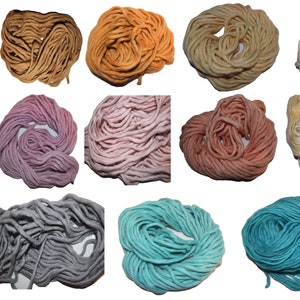 May include: A collection of 12 skeins of yarn in various colors, including brown, orange, purple, pink, gray, and blue. The yarn is arranged in rows of three, with each skein in a different color.