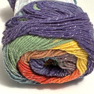 May include: A skein of multi-colored yarn with silver glitter thread. The yarn is in shades of purple, green, yellow, orange, and brown.