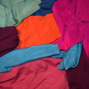 May include: A pile of colorful fabric scraps in shades of teal, orange, pink, burgundy, and blue.