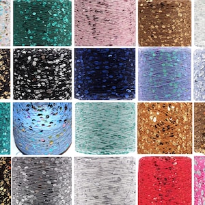 May include: A collection of spools of thread with sequins woven into the thread. The spools are arranged in a grid pattern and show a variety of colors including gold, silver, pink, blue, green, brown, and red.