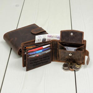 Puede incluir: Se muestran varias carteras de cuero marrón, una cerrada y dos abiertas, que revelan tarjetas, efectivo y monedas. Una cartera tiene la inscripción: "Abuelo, tu amor es el legado que llevaré en mi corazón para siempre."