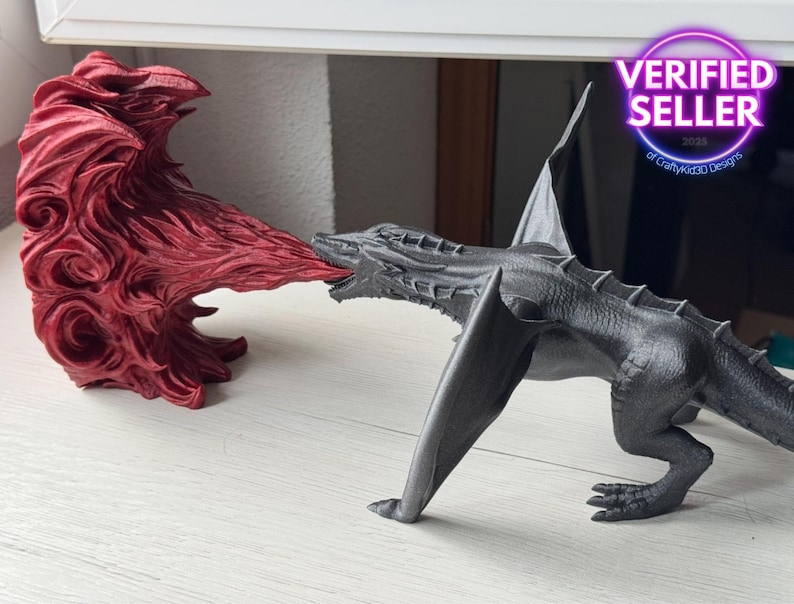 May include: A black dragon figurine with wings outstretched, breathing fire from its mouth. The fire is a separate red figurine with a swirling design.