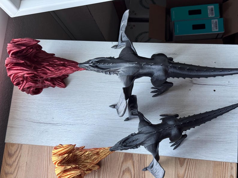 May include: Three black dragon figurines with wings, one with red flames, one with gold flames, and one with no flames.