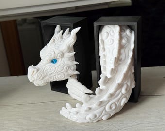 May include: A white dragon sculpture with detailed features, including a head with blue eyes and a flowing body. The dragon is partially enclosed in two black rectangular frames, creating a unique display.