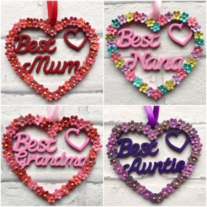 May include: Four wooden heart-shaped ornaments with a floral border. Each ornament features the text "Best" and a different title: "Mum", "Nana", "Grandma", and "Auntie".