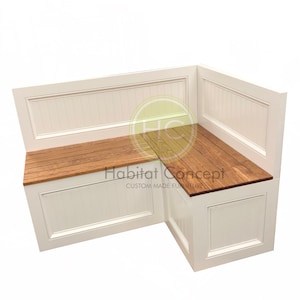 May include: White corner bench with a wood top and storage compartments. The bench has a white painted finish and a wood top. The bench has two storage compartments, one on each side. The bench is labeled "Habitat Concept Custom Made Furniture".