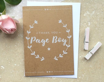 May include: A brown card with a white wreath and the text "Thank You Page Boy" in white lettering.