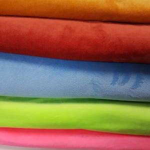 K&ouml;nnte beinhalten: F&uuml;nf Stoffmuster in verschiedenen Farben: Orange, Rot, Hellblau, Limettengr&uuml;n und Pink. Der Stoff ist weich und pl&uuml;schig.