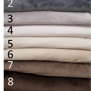 May include: Nine fabric swatches in various shades of gray, beige, and brown. The swatches are stacked on top of each other, with the darkest shade at the top and the lightest shade at the bottom. The swatches are numbered 1 through 9.