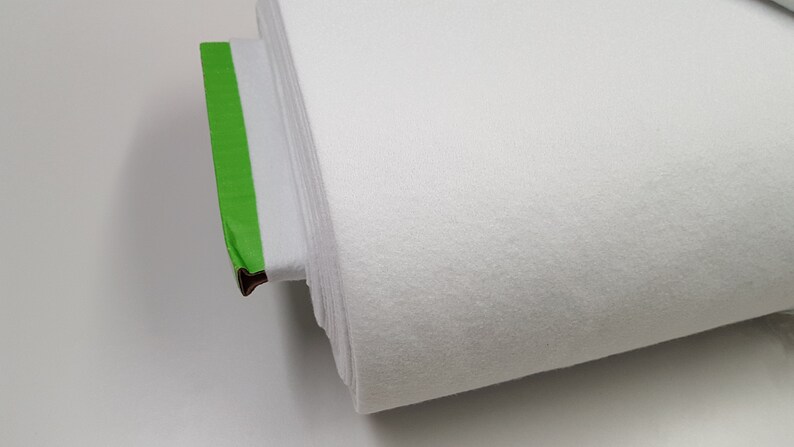 K&ouml;nnte beinhalten: Eine wei&szlig;e Stoffrolle mit gr&uuml;nem Klebeband am Ende.
