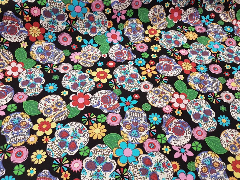 May include: Black fabric with a repeating pattern of colorful sugar skulls and flowers. The skulls are decorated with intricate designs and bright colors.