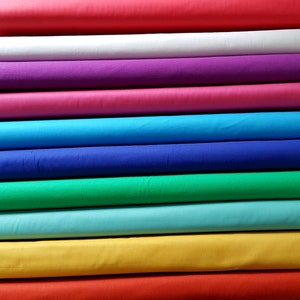 Puede incluir: Un rollo de tela de varios colores, incluyendo rojo, blanco, morado, rosa, azul, verde, turquesa, amarillo y naranja.