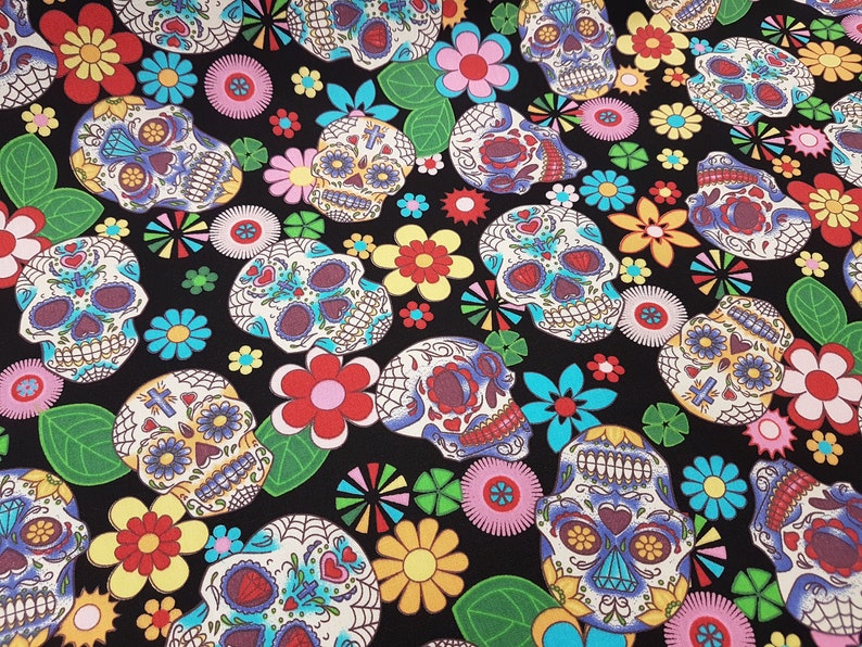May include: Black fabric with a repeating pattern of colorful sugar skulls and flowers. The skulls are decorated with intricate details and have a whimsical, festive feel.